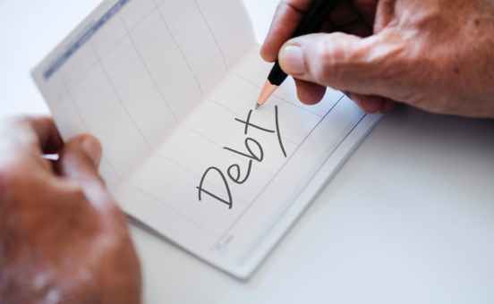 person writing debt on paper